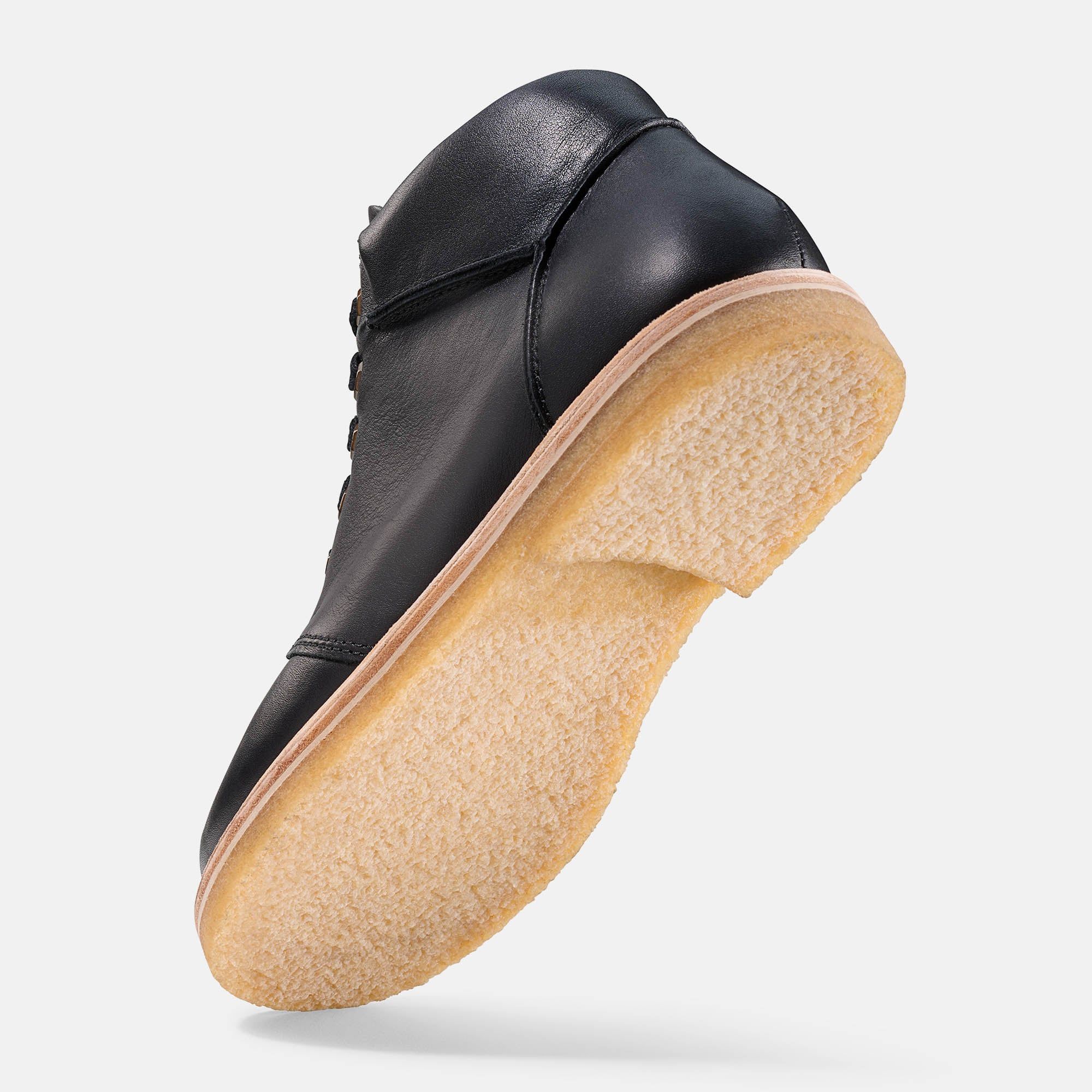 Schwarze Stiefelette für Herren. Schnürung, helle Sohle. Unteransicht der Sohle.