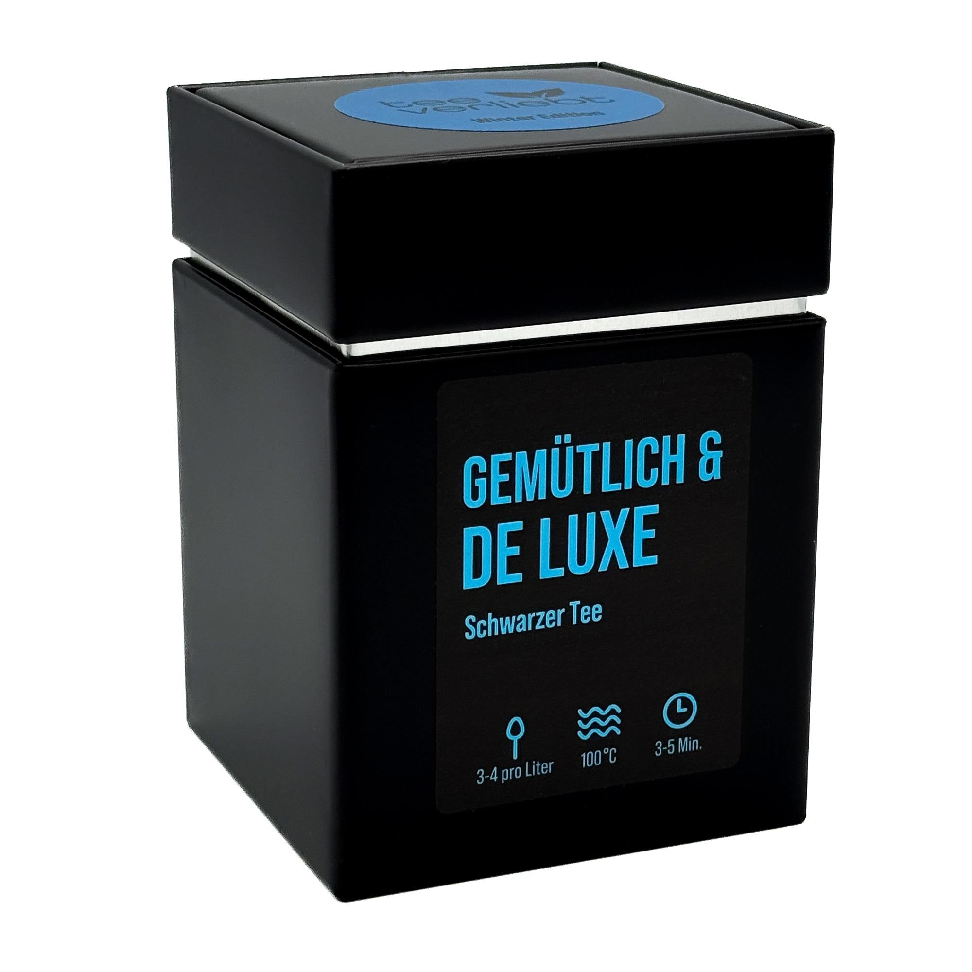 Schwarze, quadratische Geschenkdose mit blauem Deckel. Aufschrift: Gemütlich & De Luxe, Schwarzer Tee. Mit Zubereitungshinweisen.