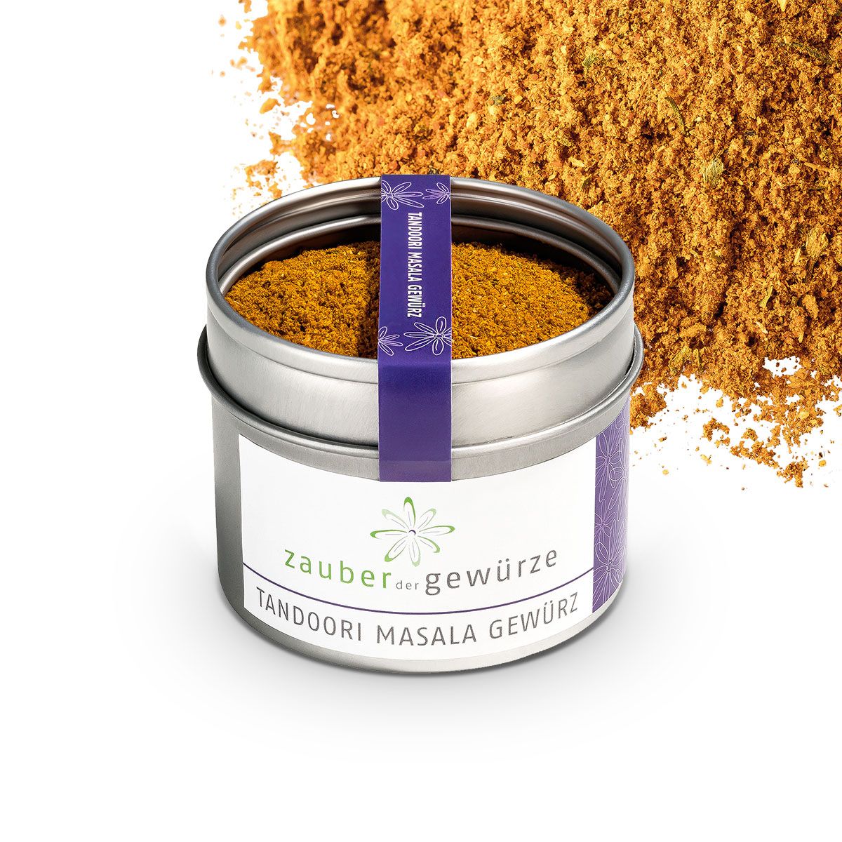 Geöffnete Metallbox mit Zauber der Gewürze Tandoori Masala Gewürz. Lila Etikett. Gewürzmischung daneben. Weißer Hintergrund.