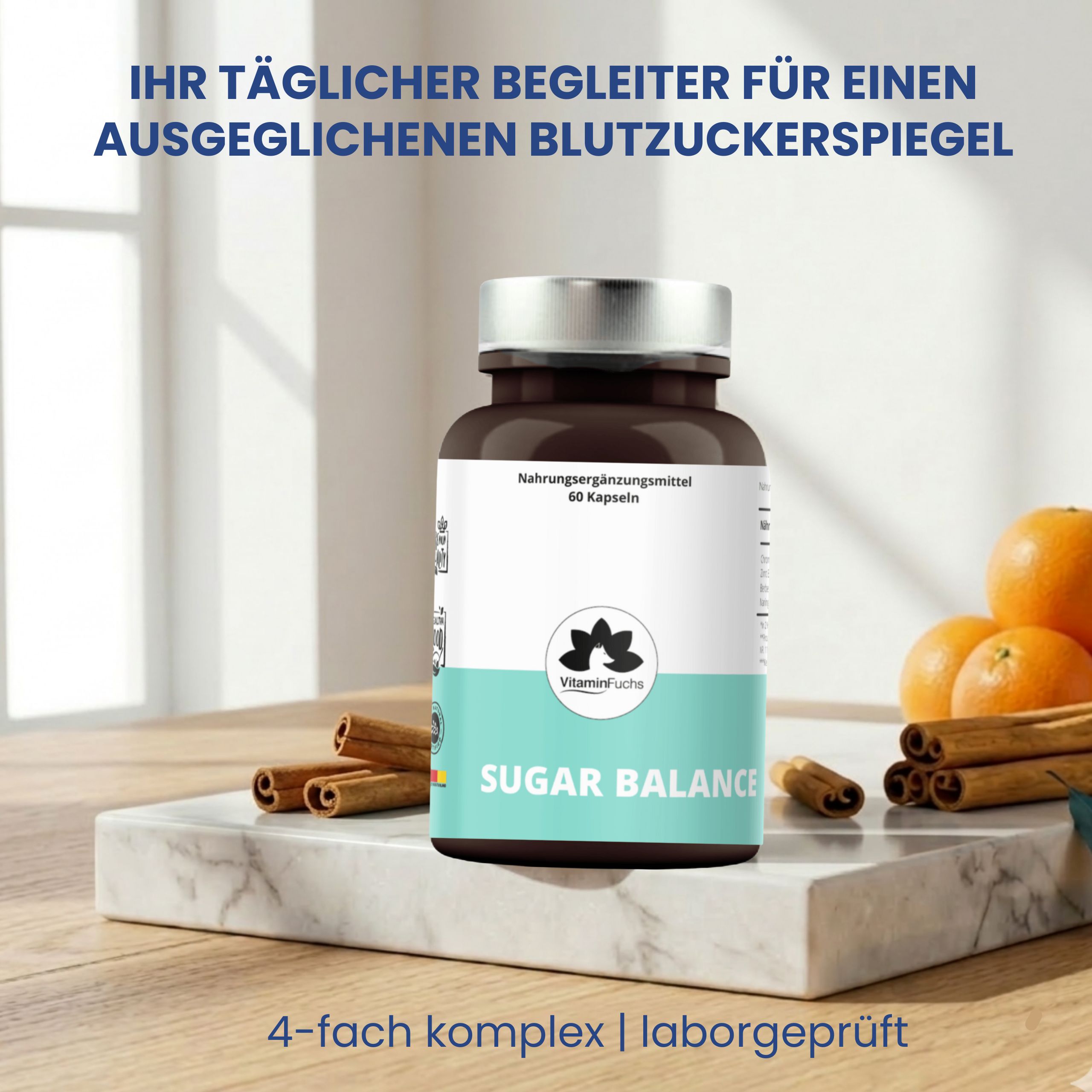 Braune Glasflasche mit silbernem Deckel. Aufschrift: Sugar Balance, VitaminFuchs. Auf einem Marmorblock mit Zimtstangen und Orangen.