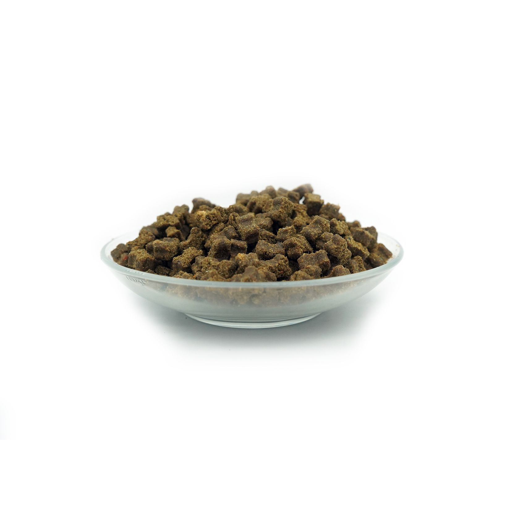 Hundefutter-Snacks in einer Glasschale. Braune, unregelmäßig geformte Stücke.