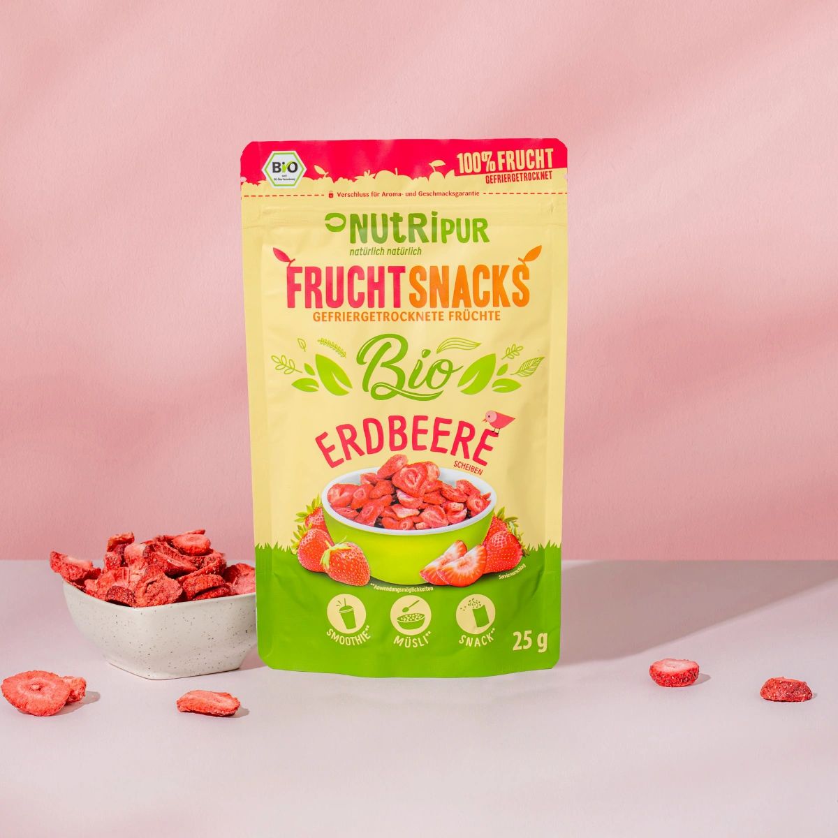 Beutel mit gefriergetrockneten Erdbeeren. Aufschrift: NutriPur, Bio, Frucht Snacks, 100% Frucht. Erdbeeren in Schale und verstreut.