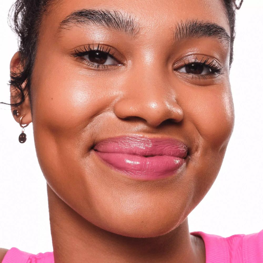 Nahaufnahme von Lippen mit rosa Lip Tint. Hautton dunkel. Ohrring sichtbar.