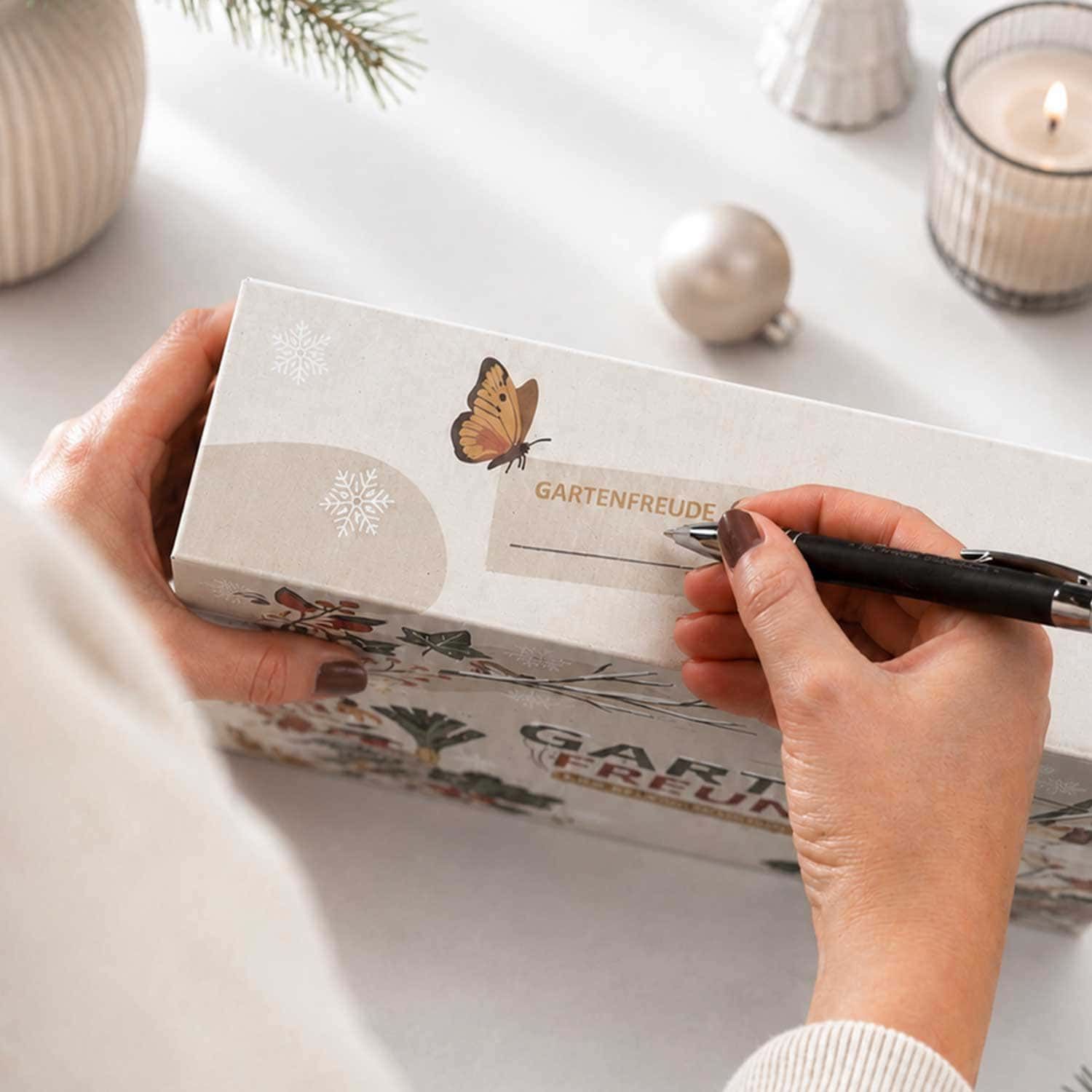 Hände schreiben auf ein Namensfeld des BIO Saatgut Adventskalenders "Garten Freund".