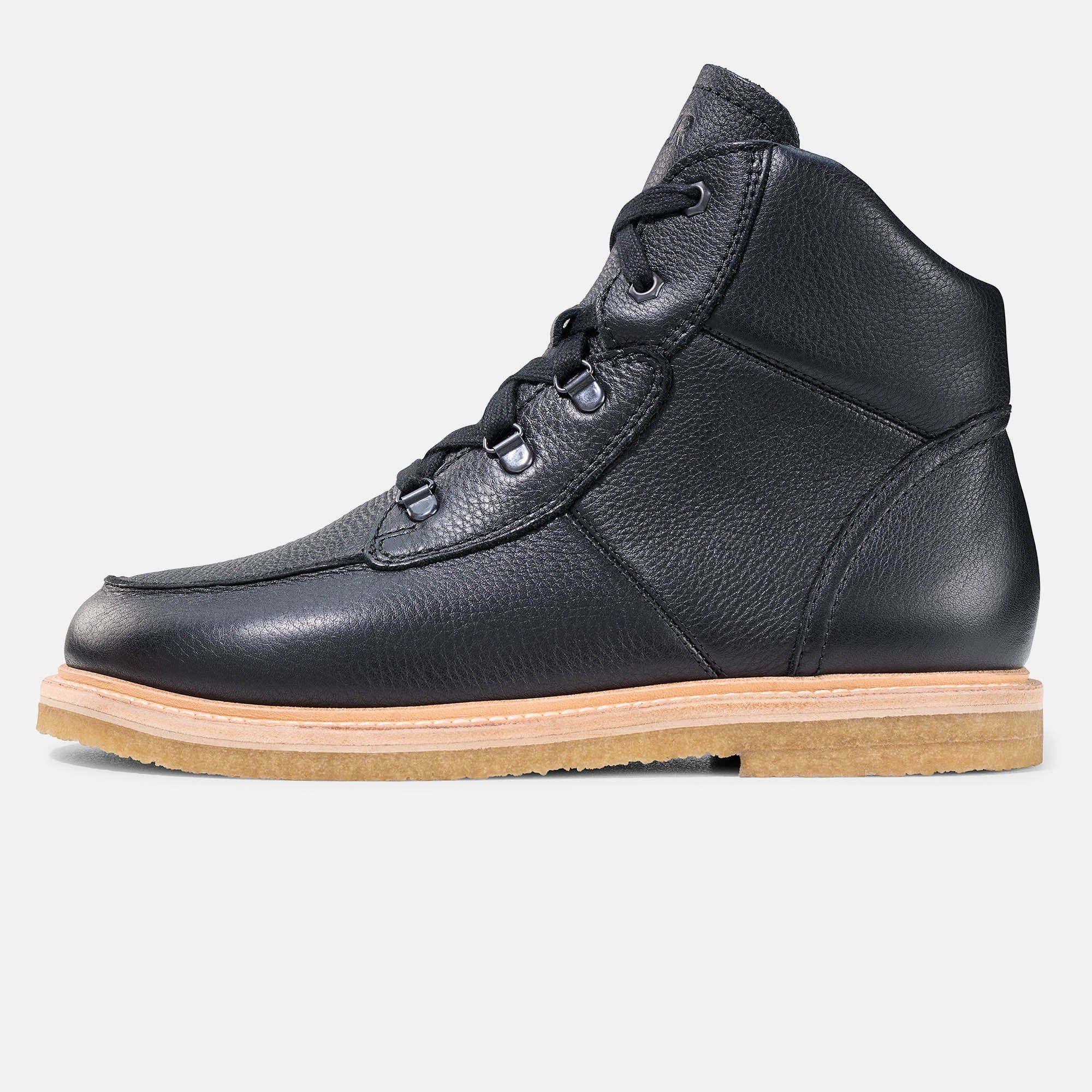 Schwarze Stiefelette mit Schnürung und heller Sohle. Lederoptik. Schuh im Profil.