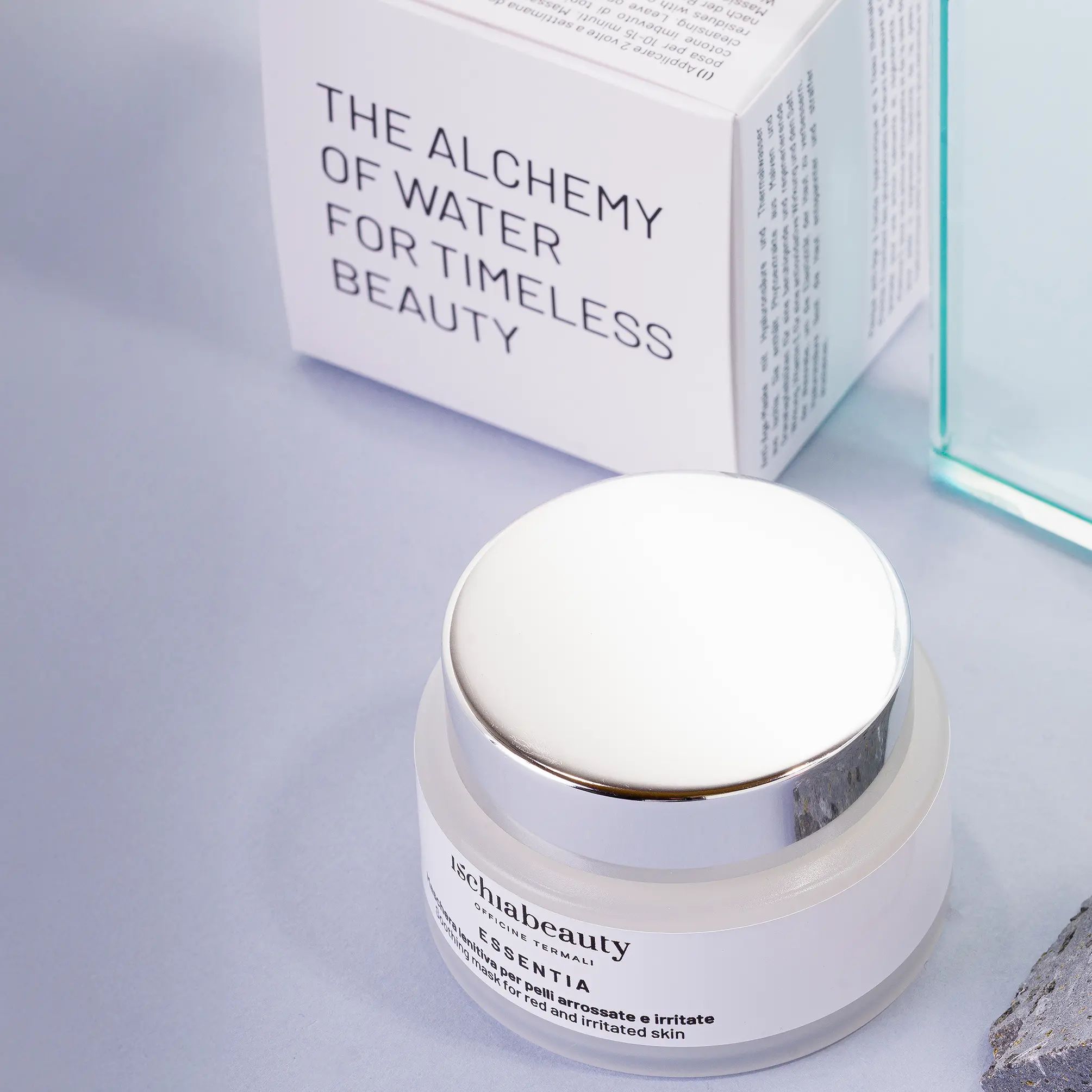 Creme-Tiegel mit silbernem Deckel und weißer Schachtel. Aufschrift: ischiabeauty, ESSENTIA, Maschera lenitiva per pelli arrossate e irritate, Soothing mask for red and irritated skin.