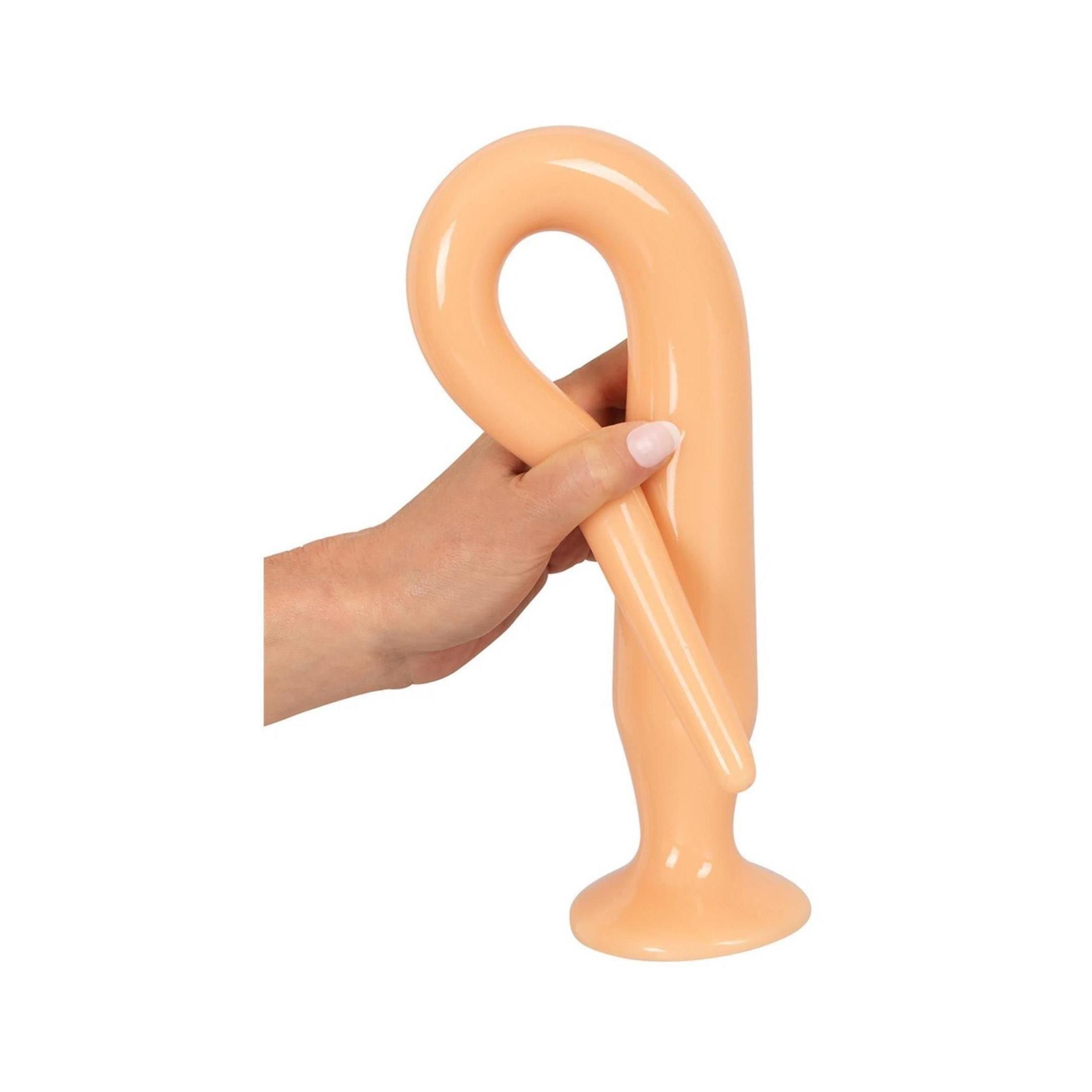 Ein hellbraunes Anal-Plug-Modell, das in einer Hand gehalten wird. Das Produkt ist in einer U-Form gebogen.