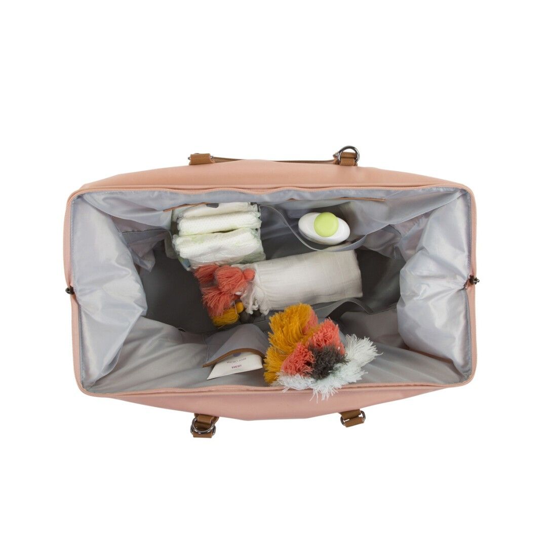Rosa Wickeltasche mit Innenfächern. Enthält Windeln, eine ovale Dose und bunte Quasten. Ansicht von oben.