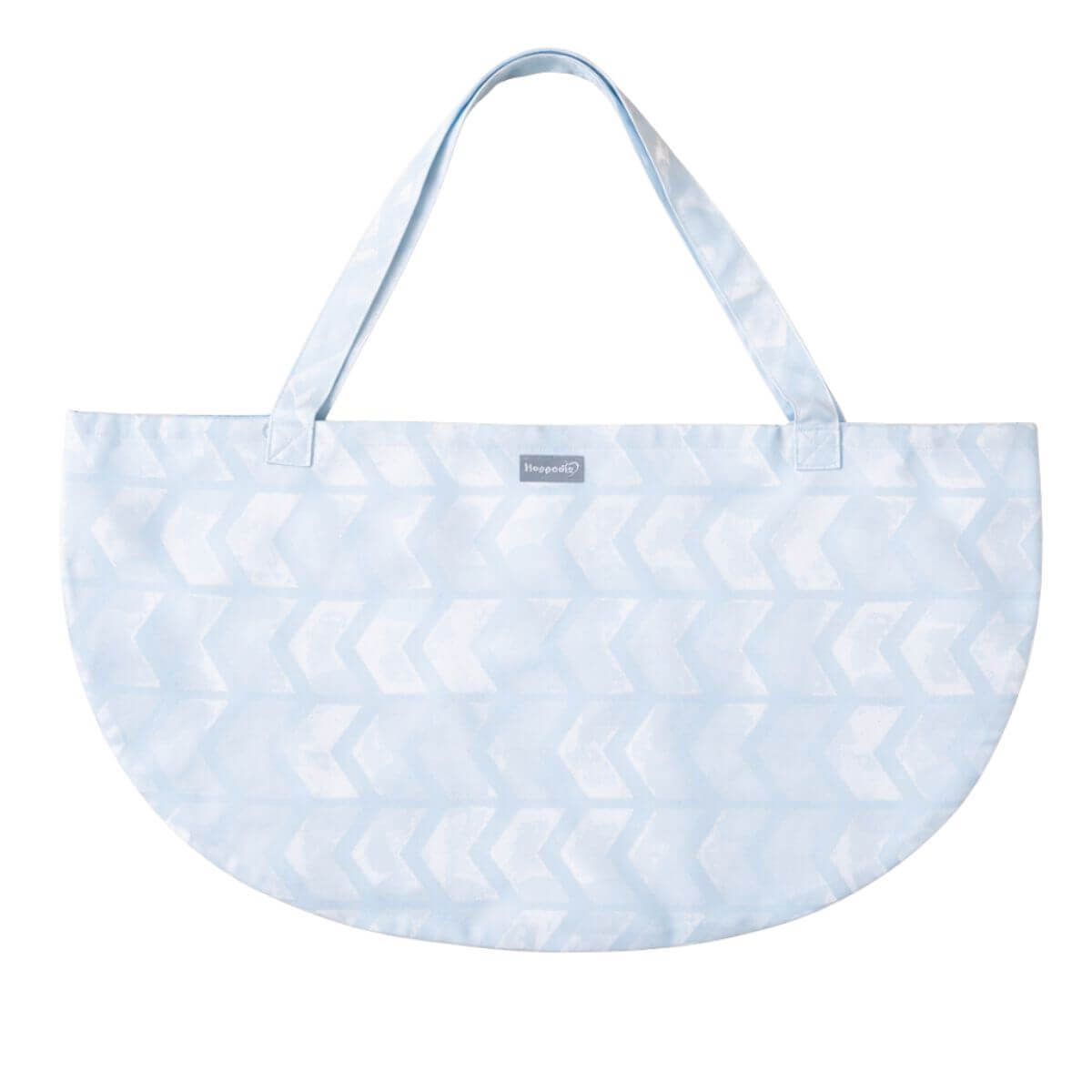 Hellblaues, halbrundes Tragetuch mit Henkeln. Muster: Pfeilförmig. Kleines Label.