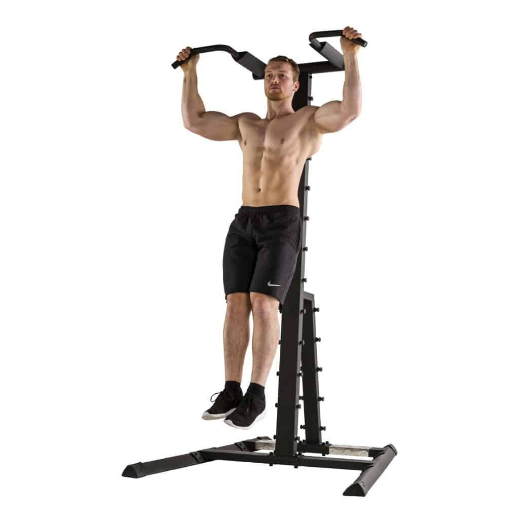 Mann trainiert an Tunturi Power Tower PT80. Klimmzüge an der Stange. Schwarzes Fitnessgerät. Muskelaufbau-Training.