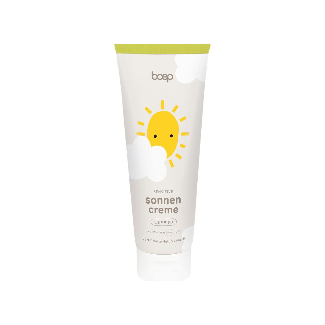 Weiße Tube mit gelbem Aufdruck. Text: "boep sonnencreme sensitiv LSF 30". Sonne und Wolken.