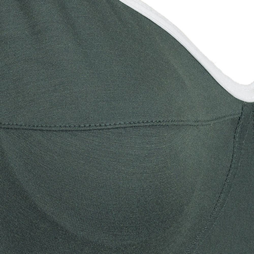 Nahaufnahme des farngrünem Still-BH. Nahtdetails und Stoffstruktur sichtbar.