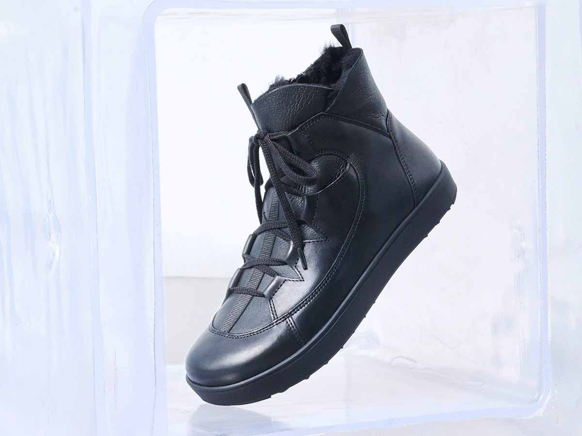 Schwarze Stiefelette in Eiswürfeln. Schnürung, Fellfutter, Gummisohle. Breite Passform. Seitenansicht.