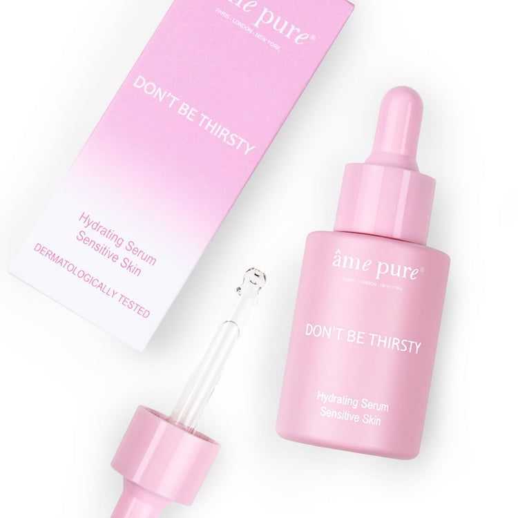 Rosa Serumflasche mit Pipette und Verpackung. Aufschrift: âme pure, DON'T BE THIRSTY, Hydrating Serum, Sensitive Skin.