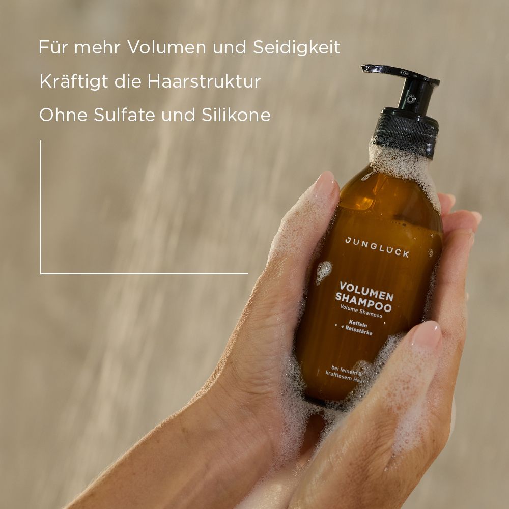 Hände halten Shampoo-Flasche mit Schaum. Text: Für mehr Volumen und Seidigkeit, kräftigt die Haarstruktur, ohne Sulfate und Silikone.