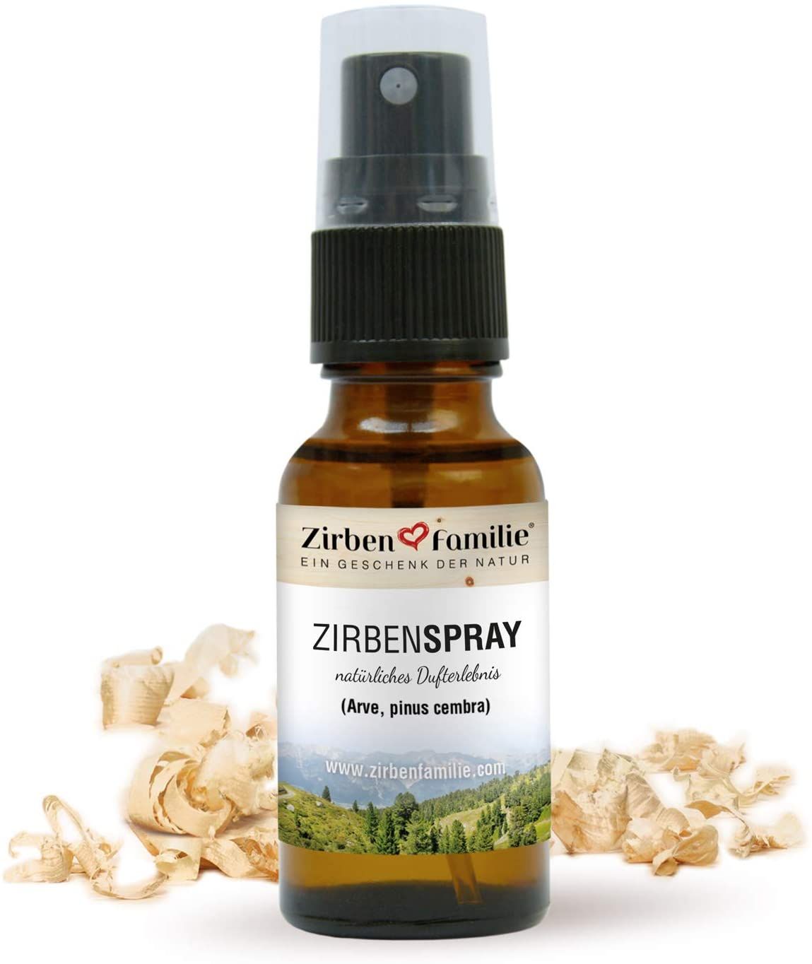 Braune Glasflasche mit Zerstäuber. Etikett mit Text und Landschaftsbild. Holzspäne im Vordergrund.