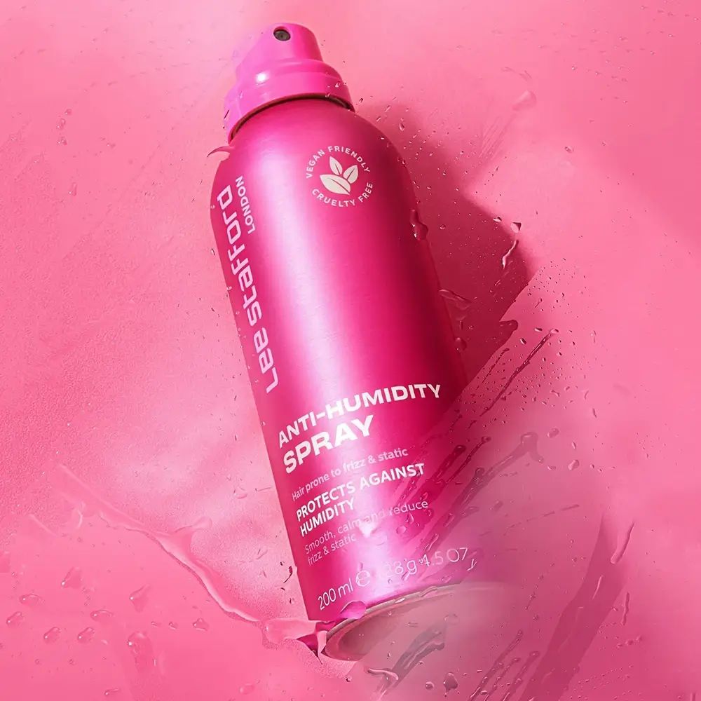 Rosa Sprühflasche 'Lee Stafford Anti-Humidity Spray' auf rosa Untergrund. Vegan- und tierversuchsfrei-Logo.