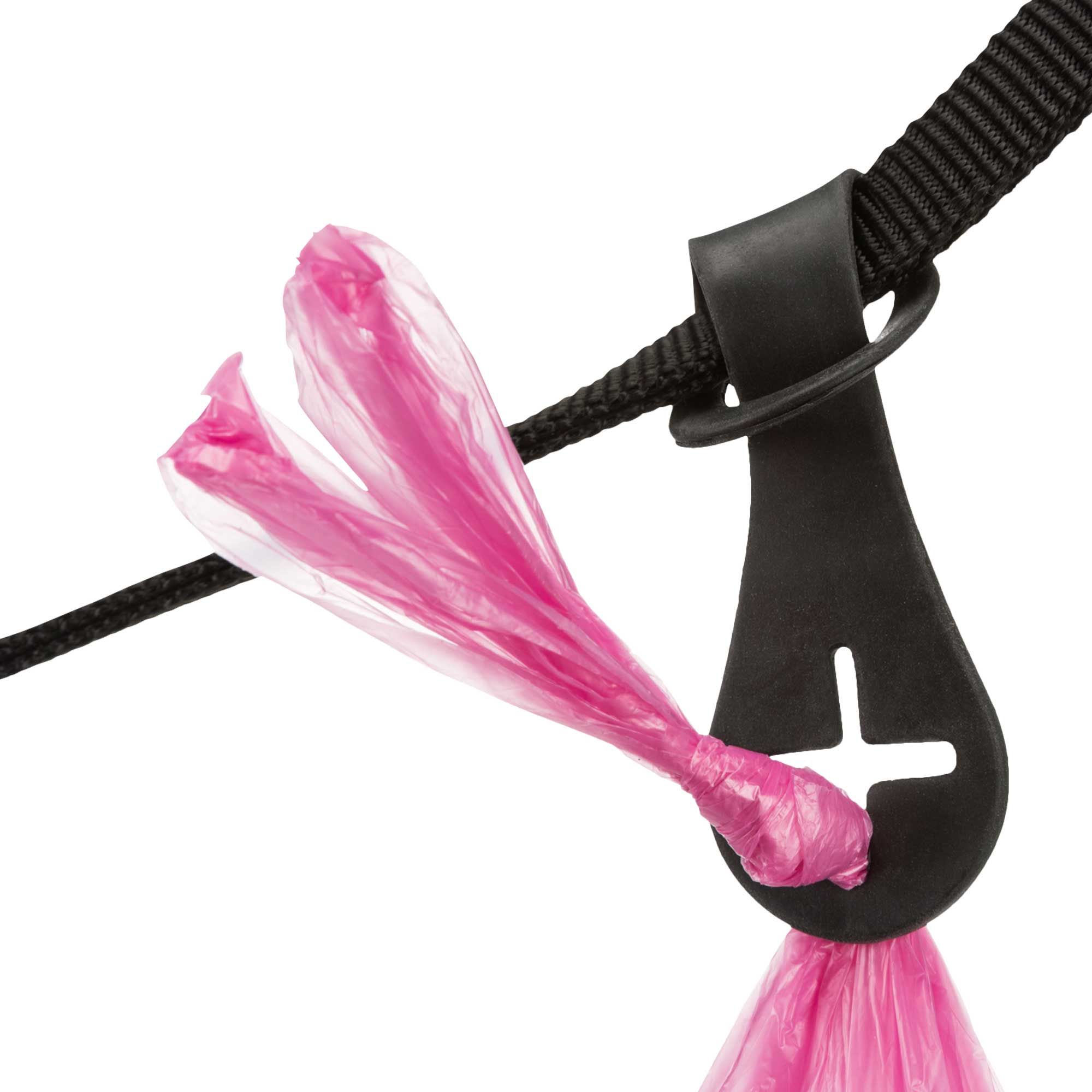 Schwarzer Kotbeutelhalter mit pinkfarbenem Beutel, an schwarzem Gurtband befestigt. Halterung mit Schlaufe und Aussparung.