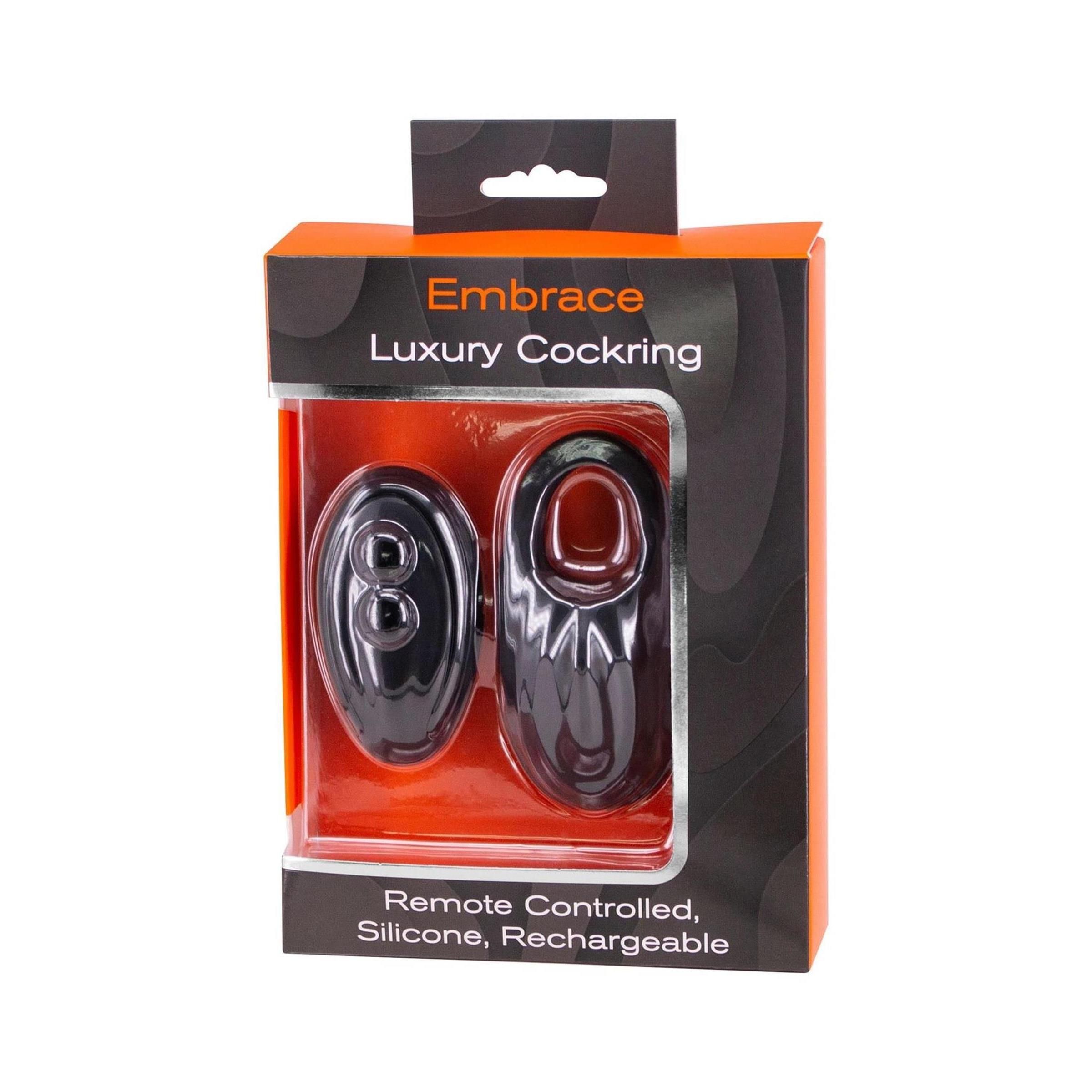 Schwarzer Cockring und Fernbedienung in Verpackung. Text: Embrace, Luxury Cockring, Remote Controlled, Silicone, Rechargeable.