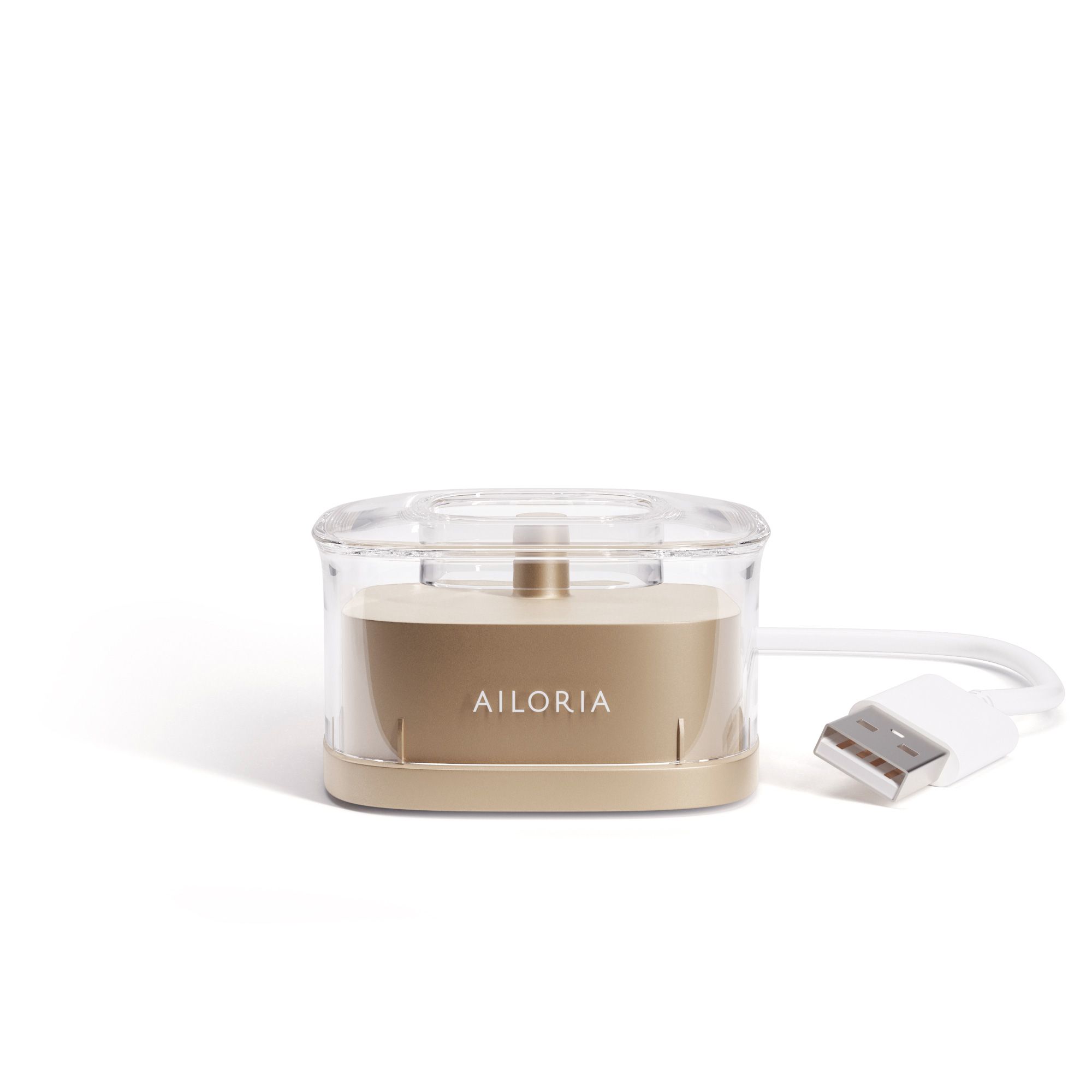 AILORIA induktive Ladestation. Goldfarbenes Gehäuse mit transparentem Deckel. USB-Kabel mit weißem Stecker.