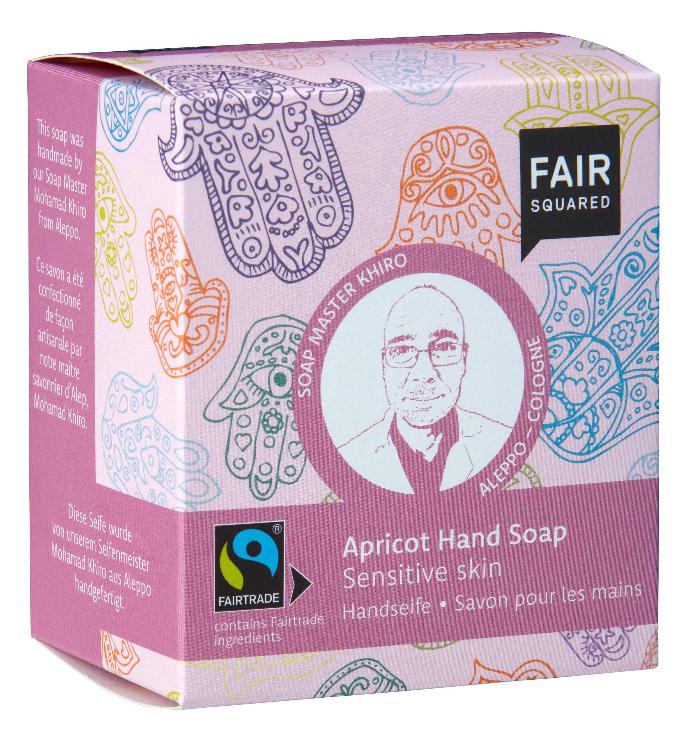 Rosa Verpackung mit FAIR SQUARED Logo und Aufdruck "Apricot Hand Soap". Fairtrade-Siegel. Abbildung von Händen.