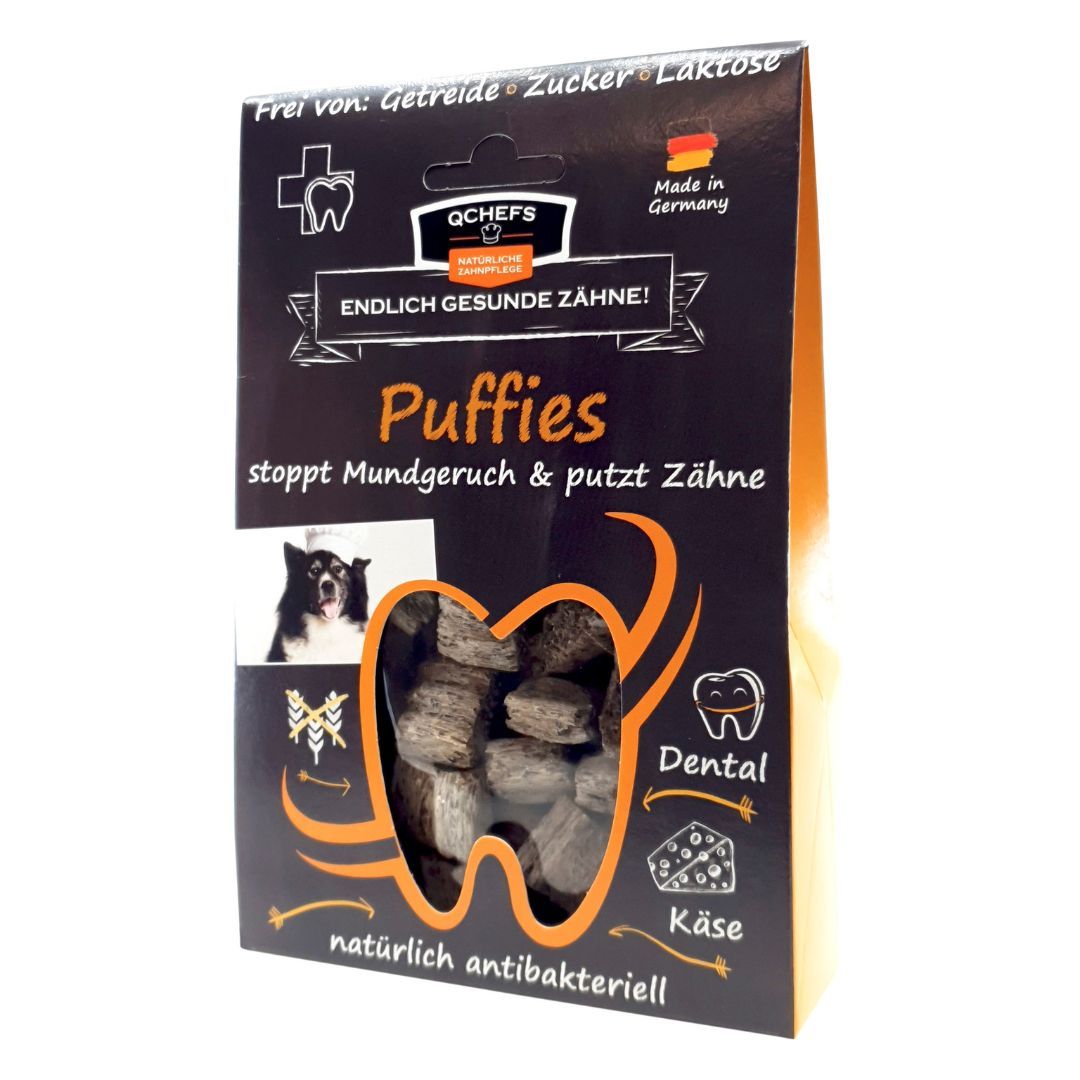 Verpackung von QCHEFS Puffies. Schwarzer Karton mit Produktnamen, Hundefoto und Zahn-Illustration. Text: Endlich gesunde Zähne!