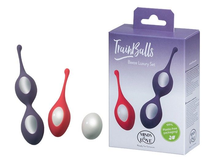 Zwei TrainBalls, rot und lila, neben einer weißen Kugel. Verpackung mit Produktnamen und Logo.