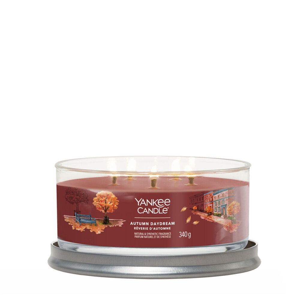 Runde Kerze im Glasbehälter. Braune Wachs, drei Dochte. Aufschrift: Yankee Candle, Autumn Daydream. 340g.