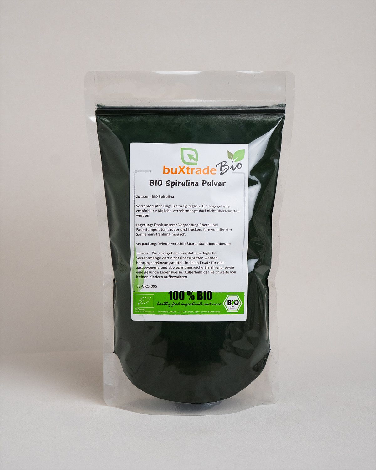 Transparente Verpackung mit buXtrade Bio Spirulina Pulver. Aufdruck mit Produktinformationen und Bio-Siegel.