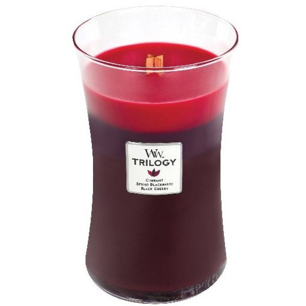 Kerze im Glas mit drei Farbschichten. Aufkleber mit "Ww Trilogy". Enthält "Cassis, Gewürznelke, Schwarzkirsche".
