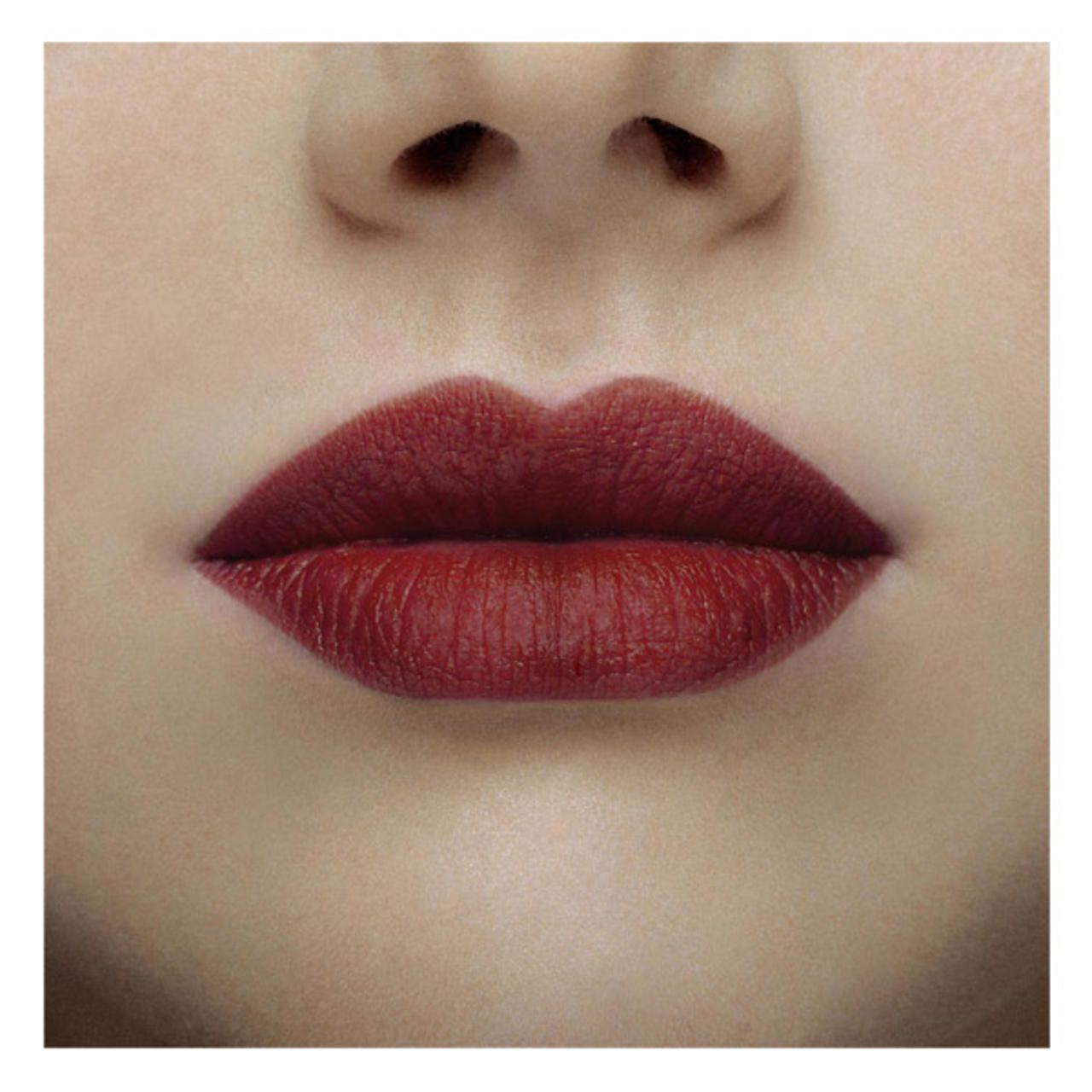 Nahaufnahme von Lippen, die mit burgunderrotem Lippenstift bemalt sind. Die Lippen sind voll und haben eine matte Oberfläche.