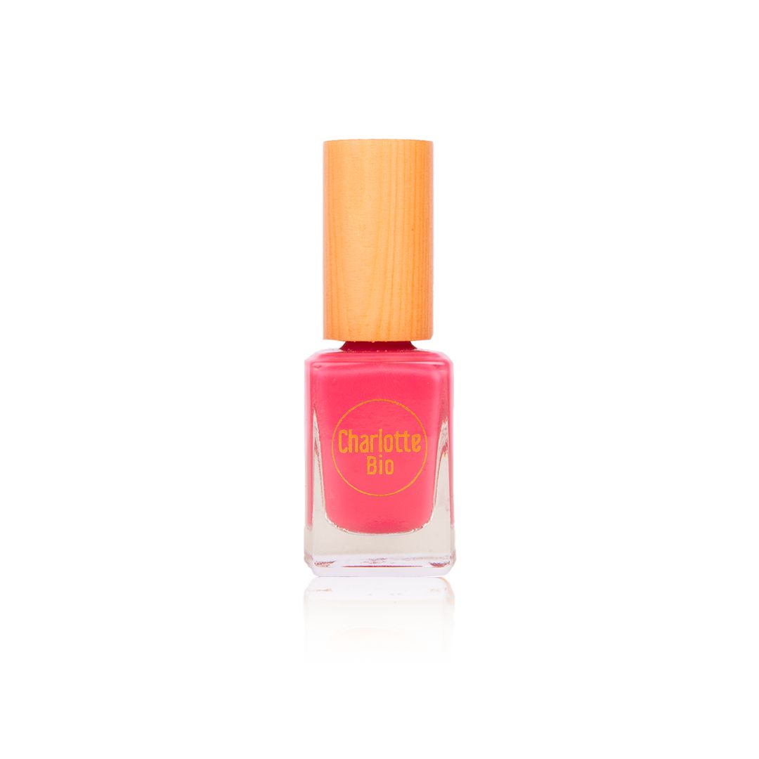 Nagellackflasche mit pinkem Inhalt und Holzdeckel. Auf der Flasche steht "Charlotte Bio".