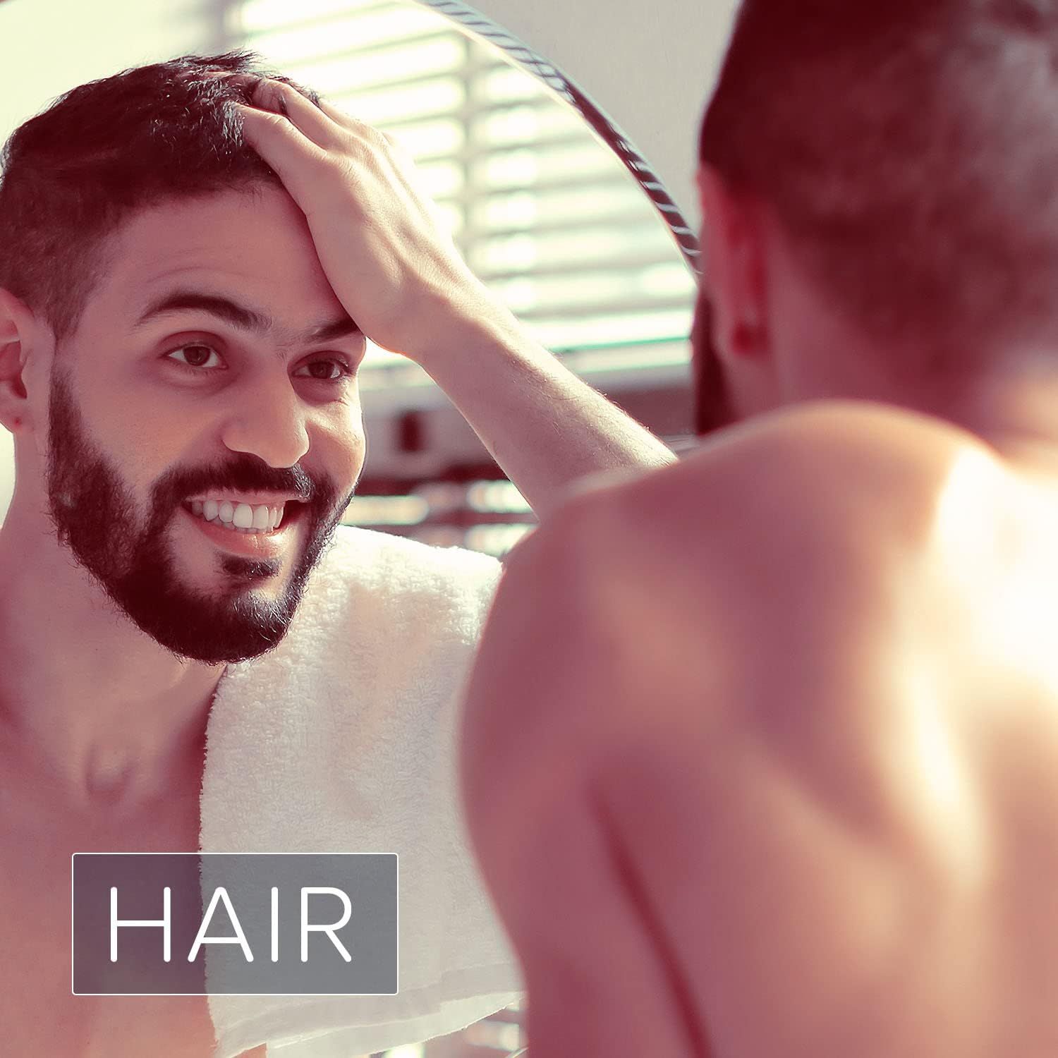 Mann betrachtet sich im Spiegel. Text: HAAR.