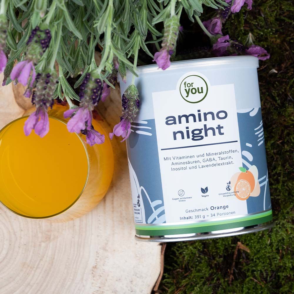 Dose "for you amino night" neben Glas mit Flüssigkeit und Lavendel. Aufdruck: Vitamine, Mineralstoffe, Aminosäuren, GABA, Taurin, Inositol und Lavendelextrakt. Orange-Geschmack.
