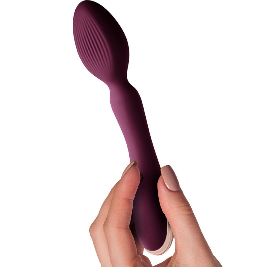 Bordeauxfarbener Stabvibrator in einer Hand gehalten. Geriffelte Spitze, geschwungene Form.
