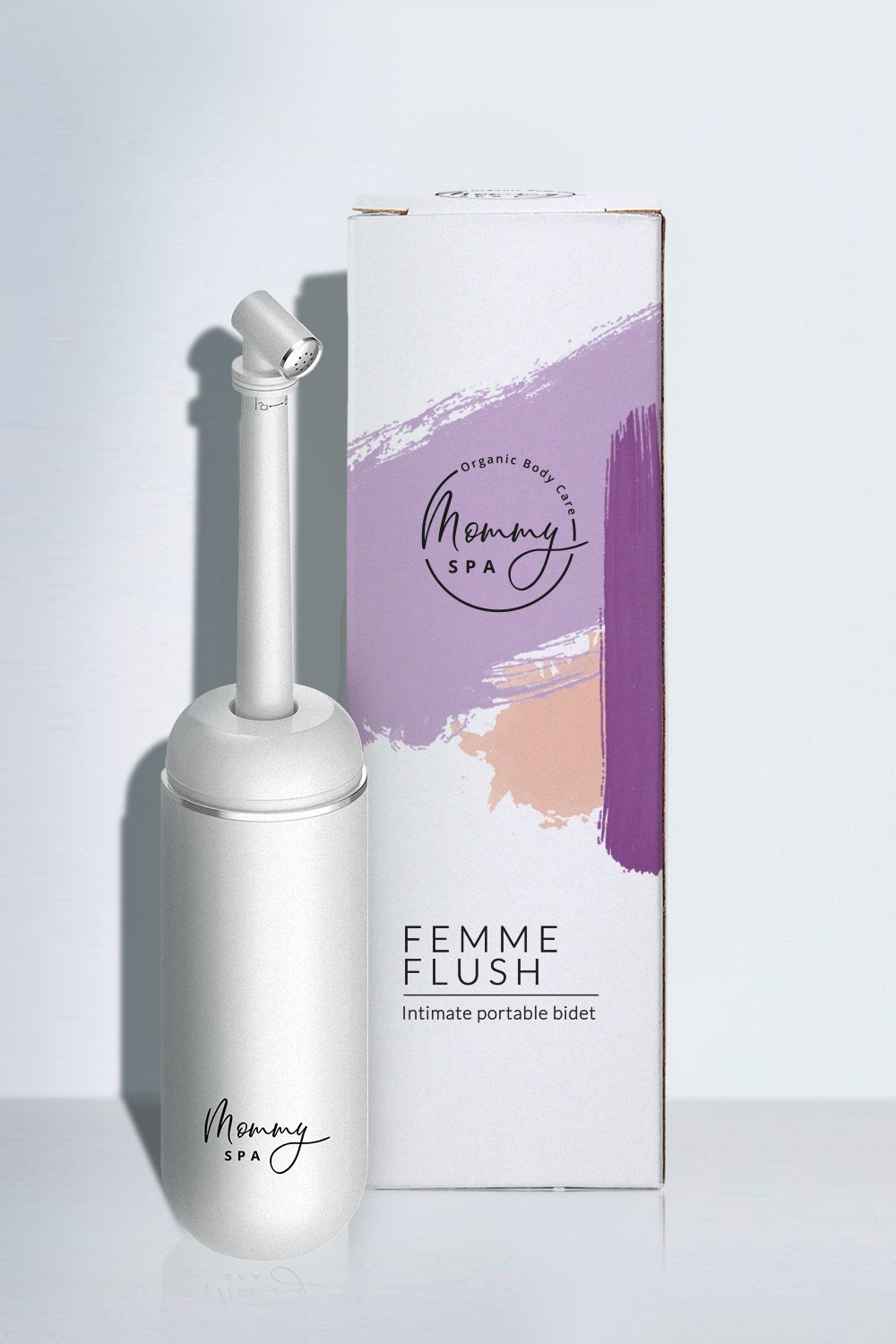 Weißes Gerät mit Verpackung. Verpackung mit Schriftzug "FEMME FLUSH" und "Mommy SPA".