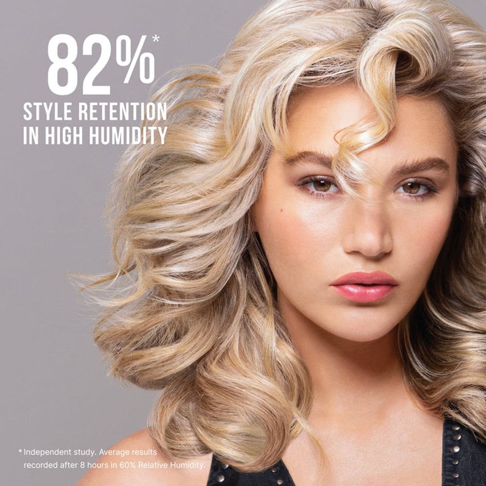 Frau mit blonden, welligen Haaren, 82% Stilhaltbarkeit bei hoher Luftfeuchtigkeit.