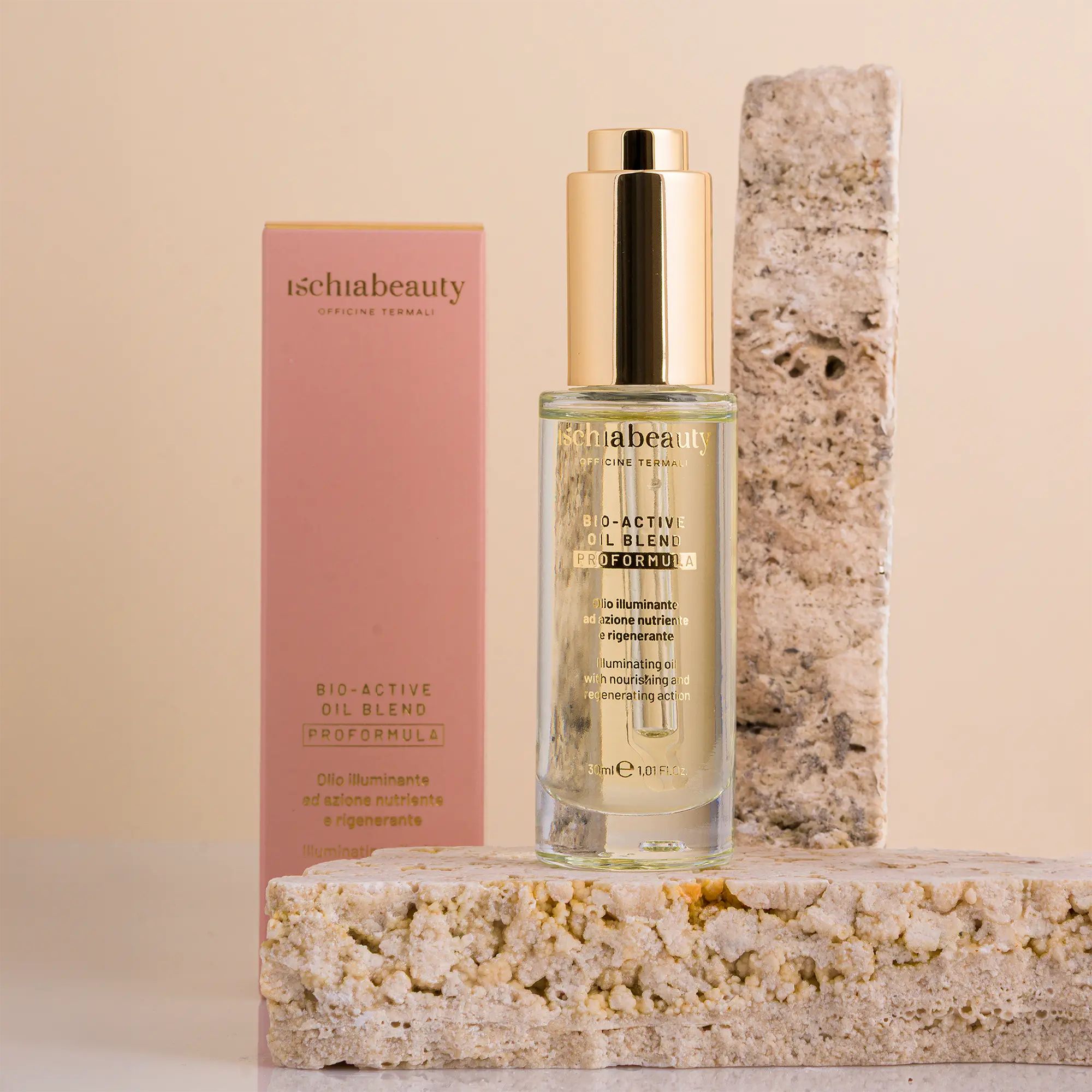 Produktflasche mit goldfarbenem Verschluss und rosa Verpackung. Aufschrift: ischiabeauty, BIO-ACTIVI OIL BLEND. Auf Steinblöcken.