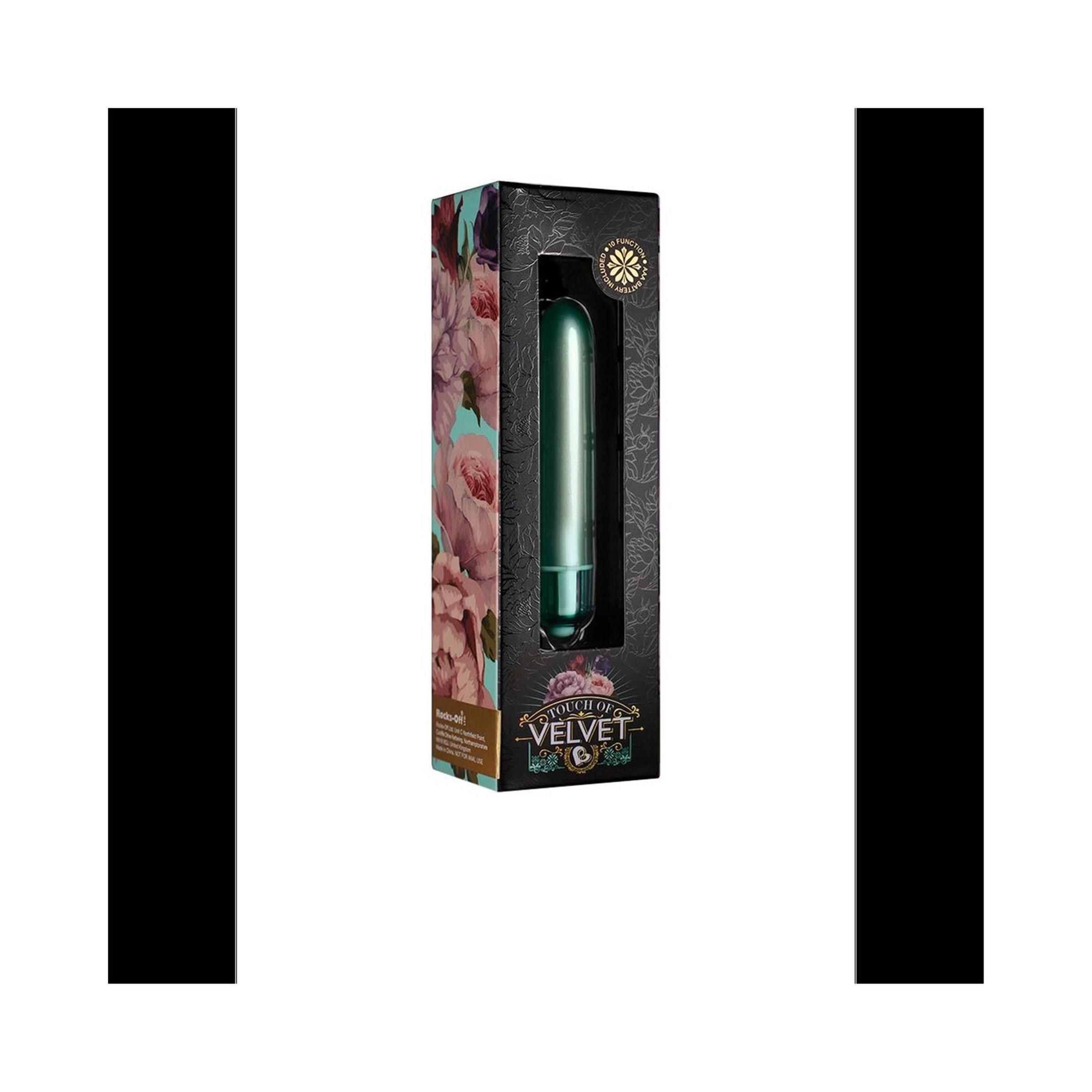 Zylindrisches Wellness-Produkt in Verpackung. Grün, mit abgerundeter Spitze. Verpackung mit floralem Muster und Produktnamen.