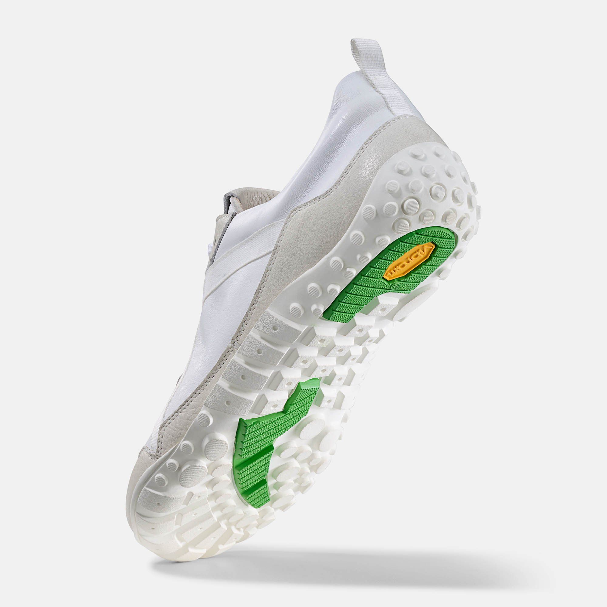 Weiße Herren-Schnürschuhe, breite Passform. Hellgraue Akzente. Schnürsenkel. Grüne Sohle mit Vibram-Logo. Unteransicht.
