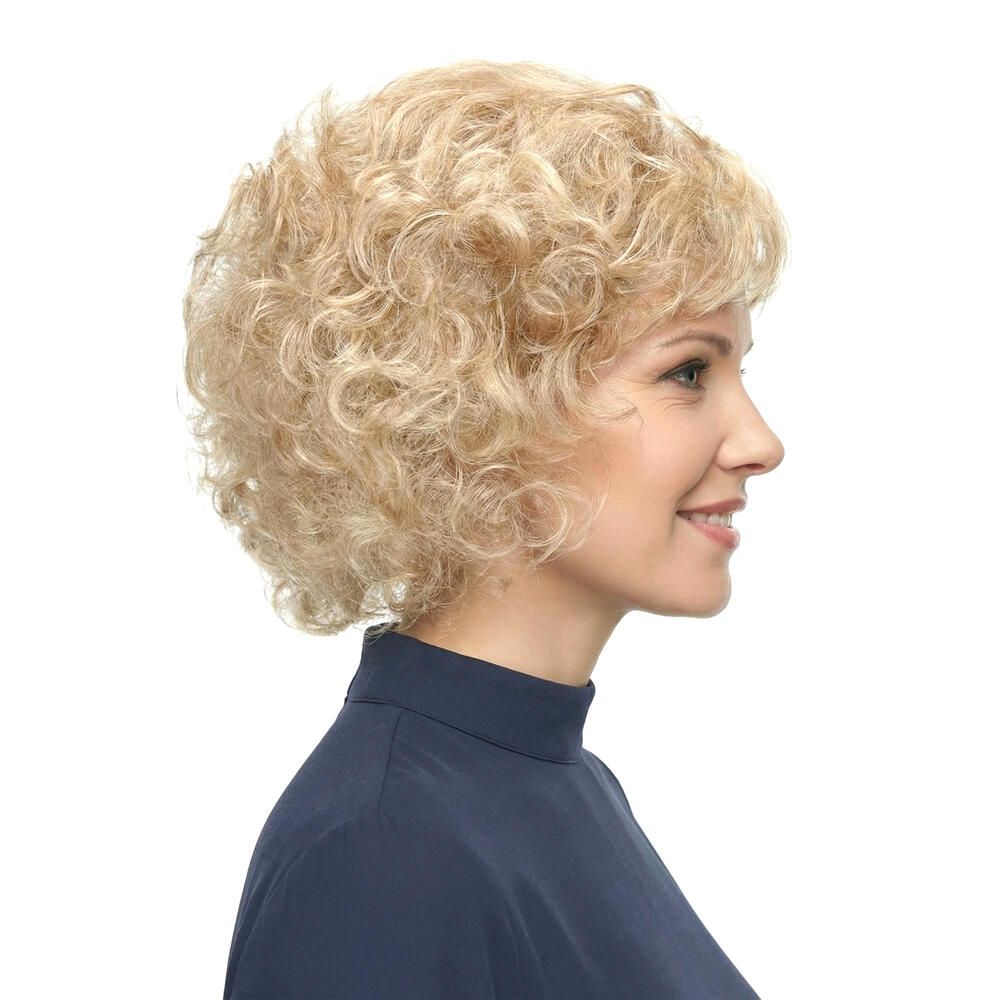 Blonde Lockenperücke, Seitenansicht. Frau mit blauem Oberteil, lächelnd. Weißer Hintergrund.