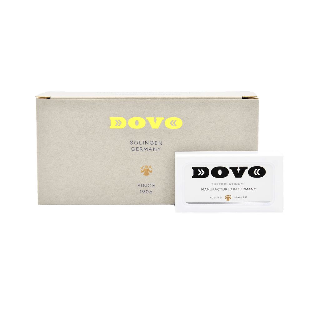 Kartonverpackung und eine Packung Rasierklingen. DOVO-Logo und Schriftzug. Goldfarbene Schrift.