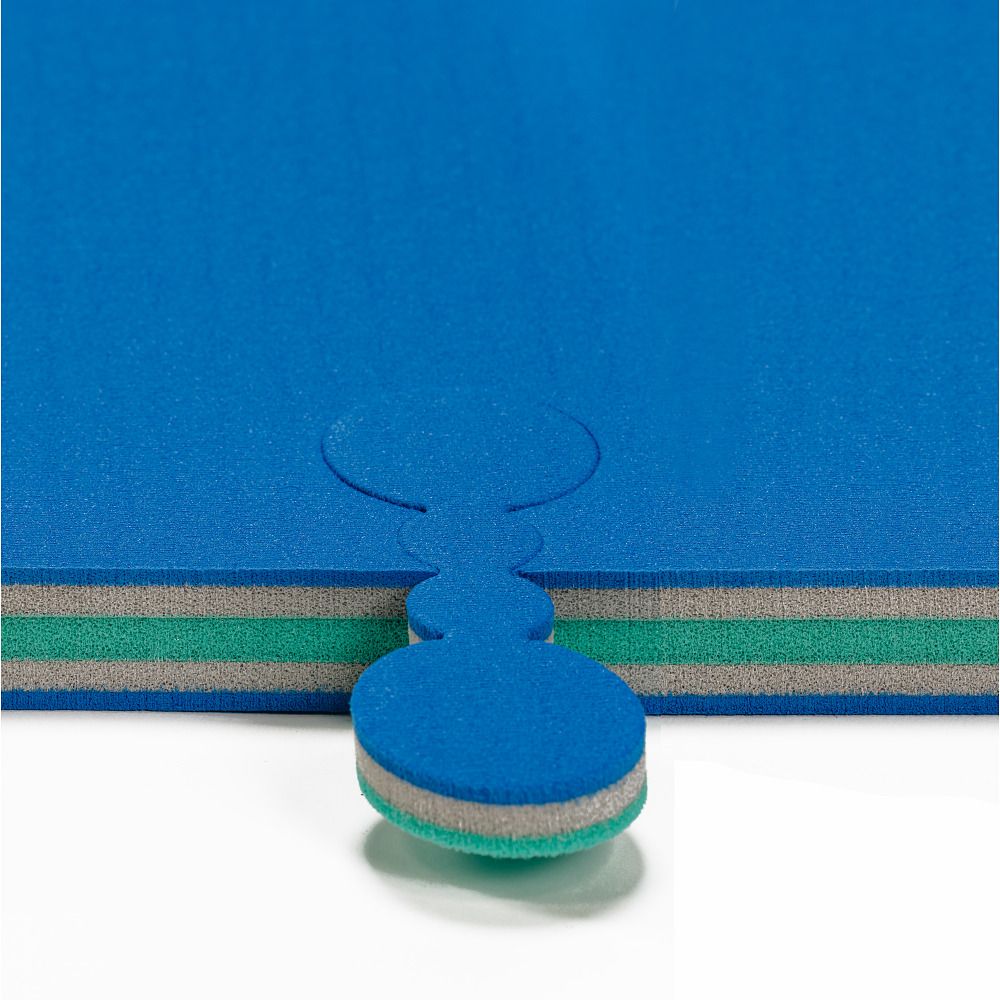 Blaues Verbindungsstück für Judomatte. Mehrschichtiges Material mit grauen und grünen Schichten. Abgerundete Form mit Aussparung.
