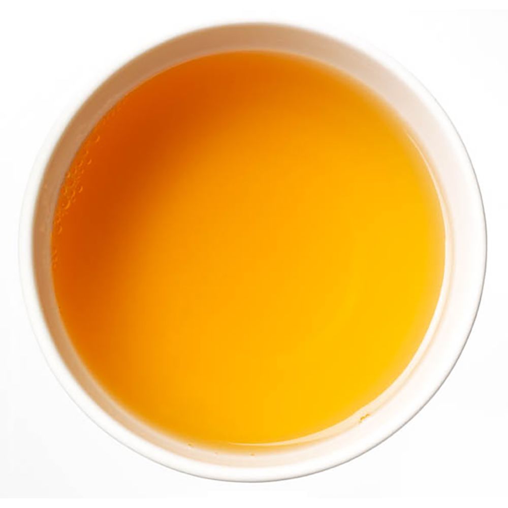 Gelber Tee in weißer Schale. Draufsicht.
