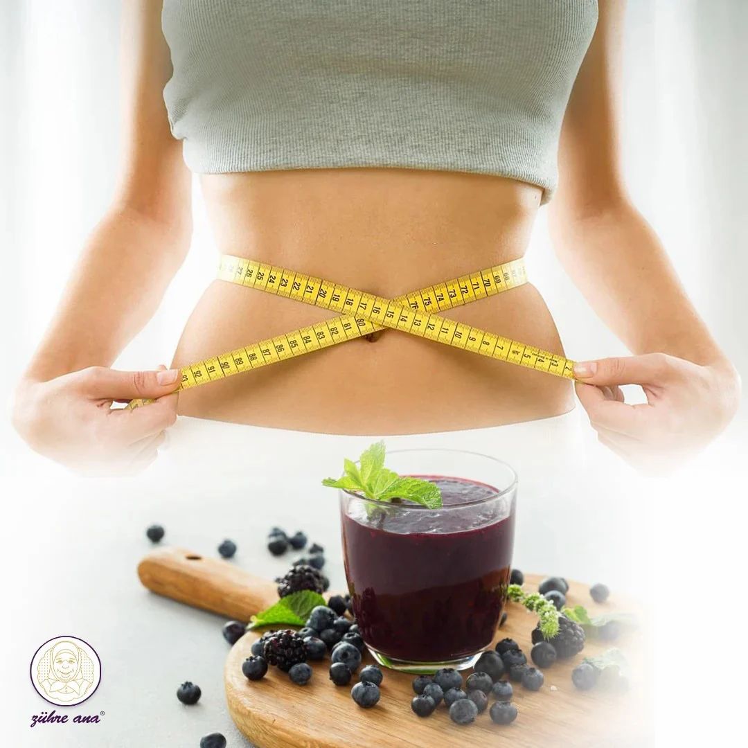 Frau mit Maßband um die Taille. Glas mit Smoothie und Beeren auf Holzbrett.