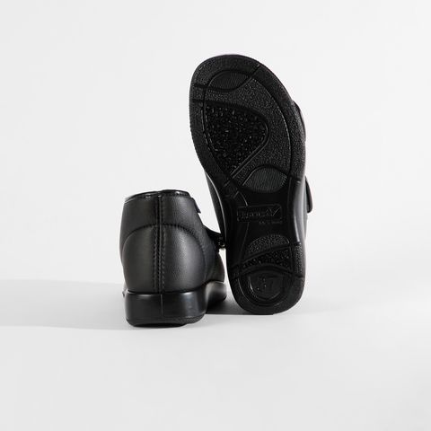 Schwarze Schuhe mit Klettverschluss und rutschfester Sohle.