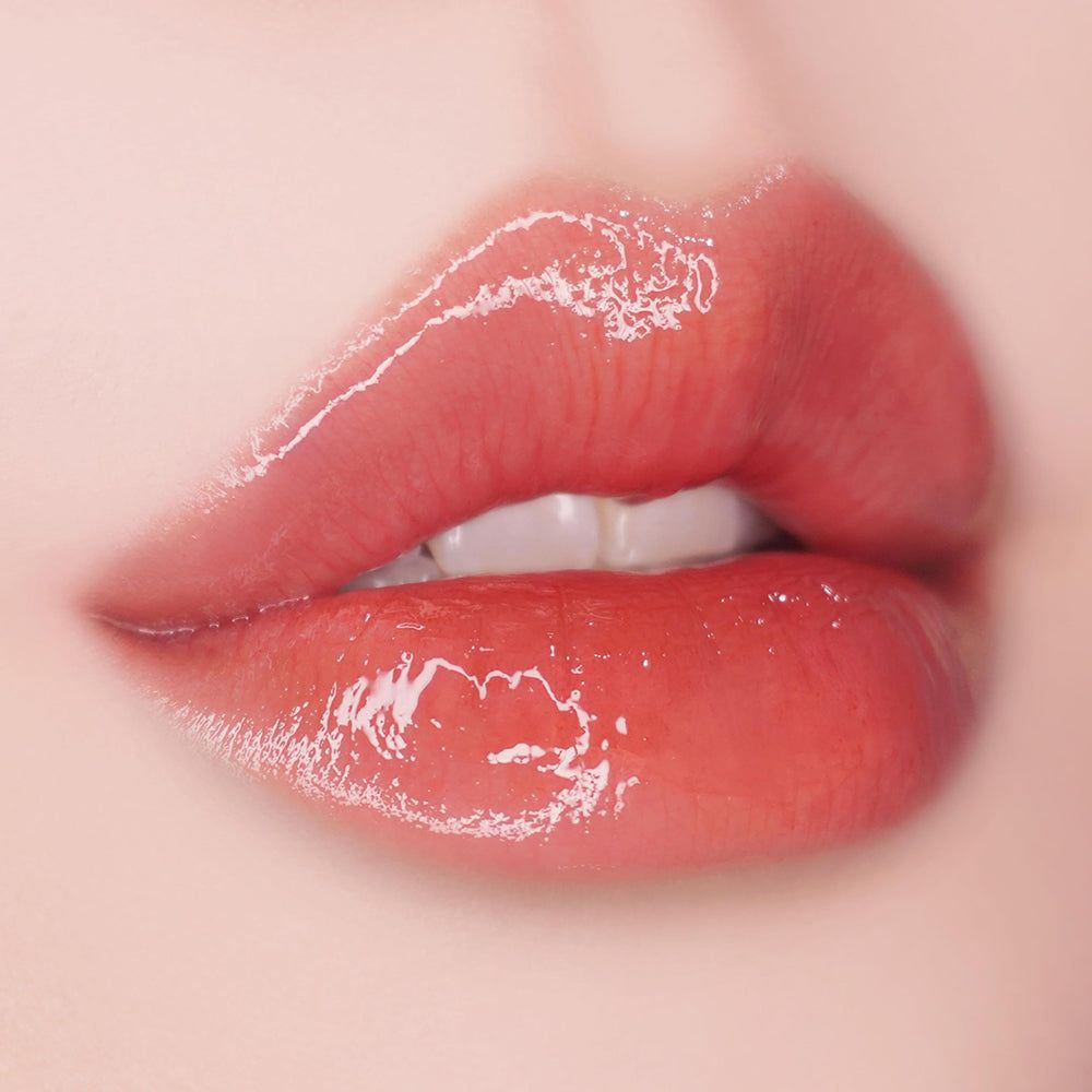 Nahaufnahme von vollen, glänzenden Lippen. Die Lippen sind rot getönt und leicht geöffnet, die Zähne sind sichtbar.