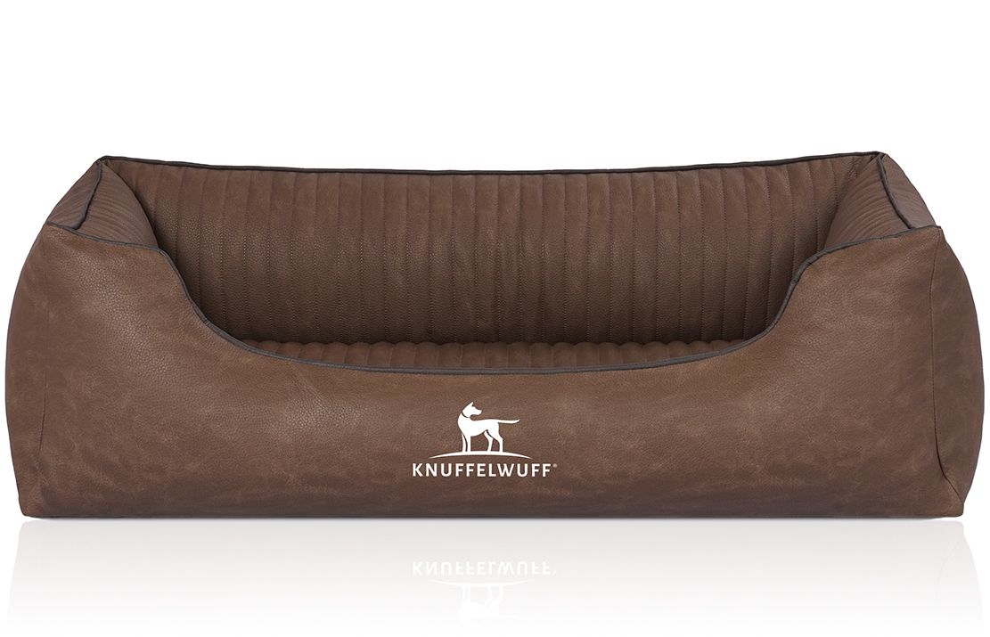 Braunes orthopädisches Hundebett. Gepolsterte Oberfläche, rechteckige Form mit erhöhten Seiten. Knuffelwuff Logo vorne.