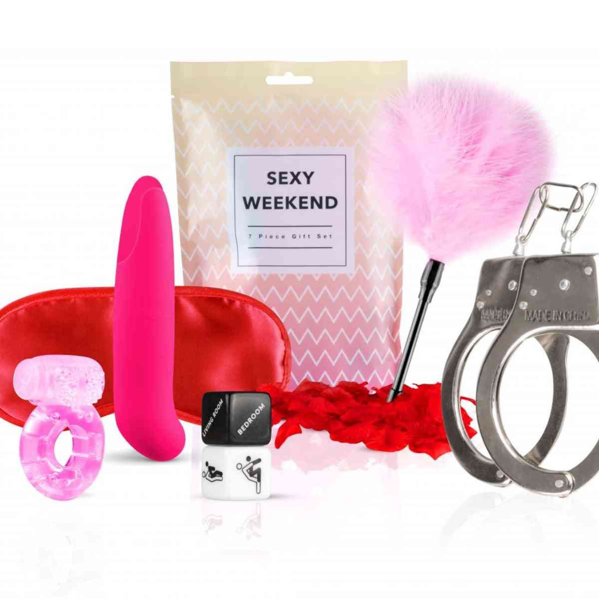 Geschenkset "Sexy Weekend" mit Zubehör: Augenmaske, Vibrator, Ring, Handschellen, Federboa, Massageöl. Verpackung mit Text.