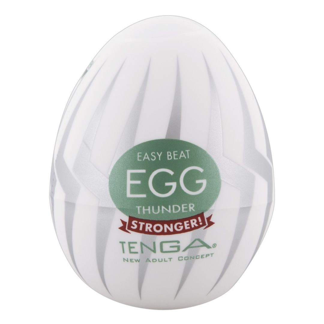 Weißes, eiförmiges Produkt mit silbernen Streifen. Grüner Aufkleber mit "EGG" und "STRONGER!". Marke TENGA.